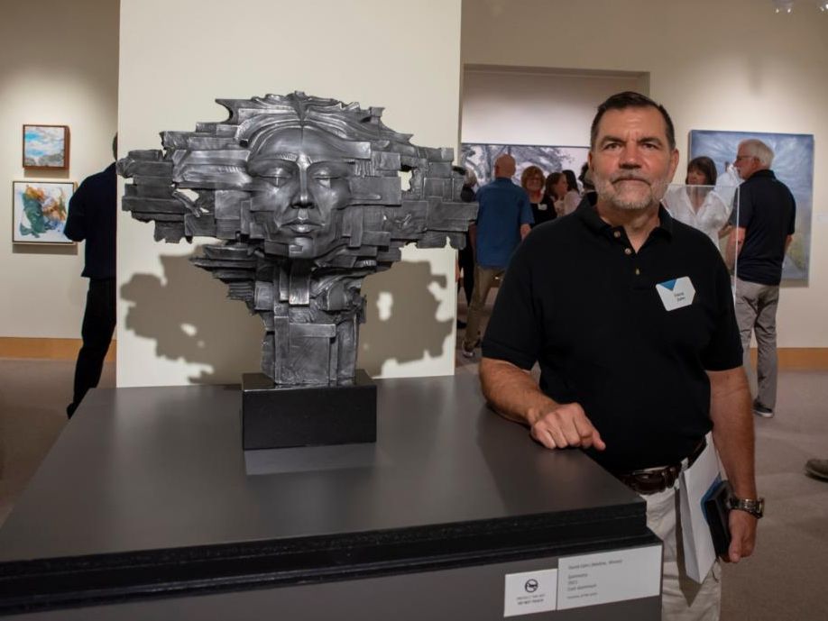 James Sizer stands next to his piece "Symmetry"