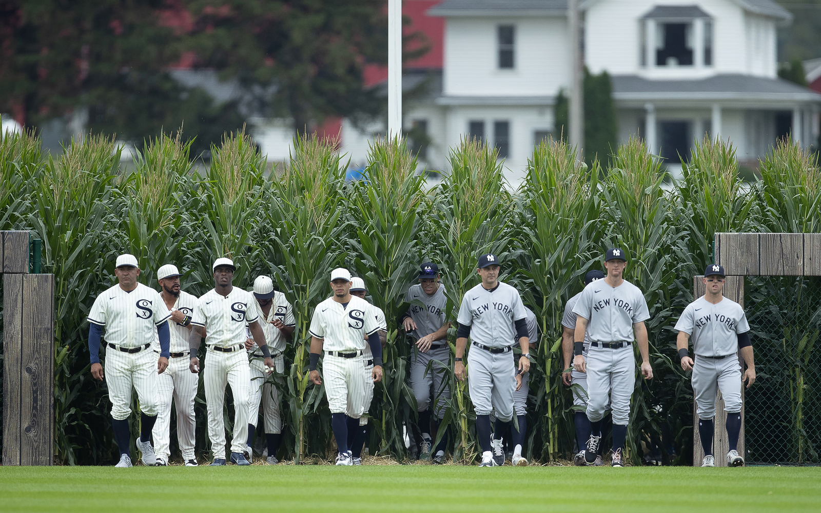 Members of the Chicago White Sox and New York Yankees walk onto the field of the first Major League Baseball game played at the Field of Dreams in Dyersville, Iowa on Thursday Aug. 12, 2021.